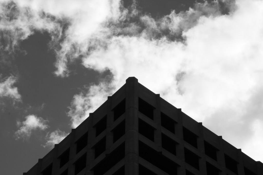 The corner of a building against a cloudy sky